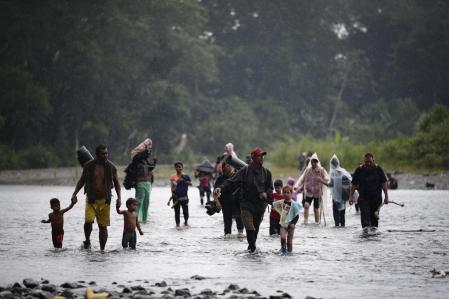Niños arrastrados por sus familias a una peligrosa travesía, cruzan el río Turquesa en la selva de Darién