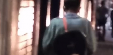 El hombre que aparece en los videos es de complexión delgada, lleva una guitarra sobre la espalda, lleva un suéter gris, pantalón oscuro y botas color café