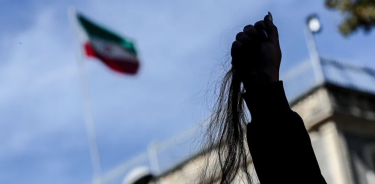 Una mujer iraní muestra un mechón de su cabello durante las protestas en su país.