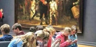 Niños absortos con sus celulares frente a la obra maestra de Rembrandt 
