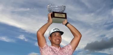 El golfista de Estados Unidos, Isaiah Salinda levanta el trofeo.