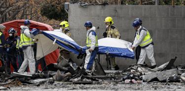 Agentes de la Policía Científica retiran con una camilla un cuerpo del edificio incendiado en el barrio de Campanar de València