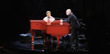 Elton John (i) mientras interpreta ‘Your Song’ con su compañero compositor Bernie Taupin