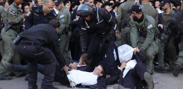 Policías retiran a manifestantes ultraortodoxos que bloquearon una vialidad frente a la oficina de reclutamiento del Ejército israelí/