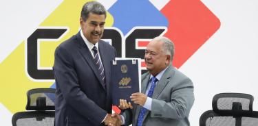 El presidente de Venezuela, Nicolás Maduro (i), y el presidente de Consejo Nacional Electoral (CNE), Elvis Amoroso, sostienen el acta de juramentación del presidente electo este lunes