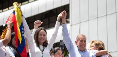 La líder opositora venezolana María Corina Machado (i) y el candidato a la presidencia de Venezuela Edmundo González Urrutia saludan en una manifestación de apoyo en Caracas