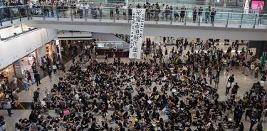 Cientos de manifestantes realizan una sentada en el aeropuerto de Hong Kong