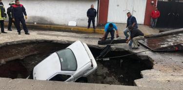 Aparece socavón en Ecatepec y caen dos automóviles