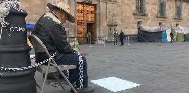 Adulto mayor se encadena a poste frente a Palacio Nacional