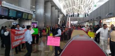 Taxistas bloquean acceso a Terminal 1 del AICM; instalan plantón