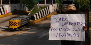 Un hombre desempleado muestra una pancarta a los conductores que pasan por la Caseta de Cobro de la carretera Tuxtla - San Cristóbal de las Casas (Cuartoscuro)