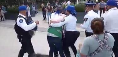 Policías intentan defender a servidora pública agredida