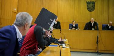 El terrorista identificado como A. J. se cubre la cara durante la sesión para leer la sentencia en su contra, este martes en Fráncfort, Alemania.