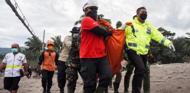 Rescatistas cargan el cuerpo de una víctima de la erupción