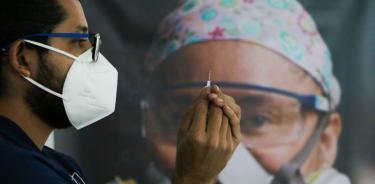 Un enfermero prepara una vacuna para aplicarla y medir eficacia