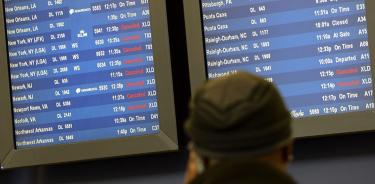 Pasajeros contemplan la pantalla con los vuelos cancelados, en una fotografía de archivo.