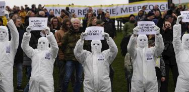 Varias personas protestan este domingo 2 de enero, con trajes sanitarios a modo de ironía, contra las restricciones por la pandemia en Ámsterdam.