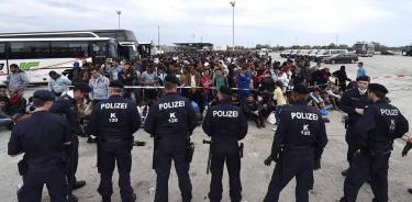 Policías vigilan a un grupo de refugiados en Nickelsdorf, Austria, junto a la frontera con Hungría.