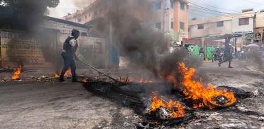 Un policía intenta disipar una barricada en llamas durante una protesta en Pétion-Ville, Puerto Príncipe, capital de Haití, este jueves 6 de enero.