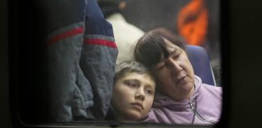 Una madre y su hijo huyen de Kiev