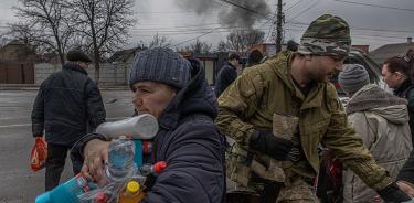 Una anciana recibe agua y productos de limpieza de manos del ejército en un reparto en Irpin, región de Kiev, este jueves 3 de marzo de 2022.