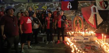 Aficionados del Club Atlas, encienden velas en la madrugada de este domingo, en las inmediaciones del estadio Jalisco