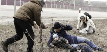 Un padre sostiene a su bebé en brazos, tras caer toda la familia al suelo por el impacto de una bomba rusa que explotó cerca, a las afueras de Irpin, cerca de Kiev.