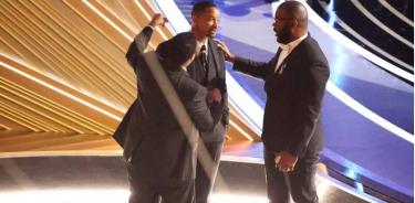 Denzel Washington y Tyler Perry, a la derecha, conversan con Will Smith en los Oscars.