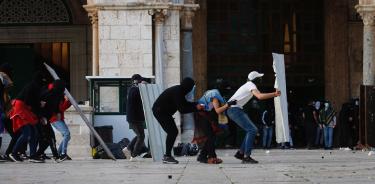 Palestinos se enfrentan a la policía israelí dentro del recinto de la mezquita sagrada de Al Aqsa, este viernes 22 de abril de 2022 en Jerusalén.