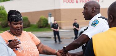 Un policía consuela a una mujer en la escena del atentado racista contra la comunidad negra de Búfalo, Nueva York, este sábado 14 de mayo de 2022.