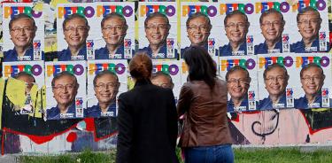 Personas pasan frente a carteles propagandísticos del izquierdista Gustavo Petro, ste viernes 27 de mayo de 2022 en Bogotá.
