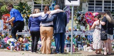 Personas se duelen frente a las cruces colocadas en Uvalde, Texas, como recuerdo a los niños muertos en el tiroteo, este sábado 28 de mayo de 2022.