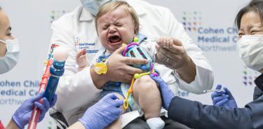 Un bebé llora tras ser inyectado con la vacuna contra la covid en un hospital de Nueva York