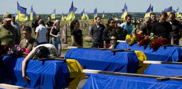 Familiares y amigos participan en la ceremonia de entierro de los cuerpos de 13 soldados caídos, que fueron sepultados este viernes 1 de julio de 2022 en Dnipro, Ucrania.