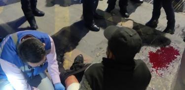 Un hombre es atendido por personal de Seguridad Industrial del Metro tras ser atacado con un arma punzocortante afuera de la estación Morelos.