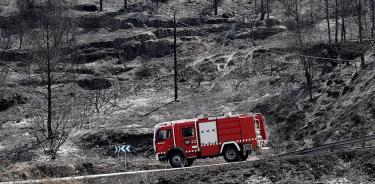 Un camión de bomberos circula por una zona arrasada por las llamas en El Pont de Vilomara, Bages, Barcelona, este lunes 18 de julio de 2022.