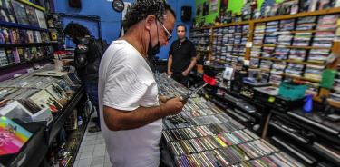 Personas buscan material discográfico en la tienda de rock 