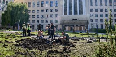 Policías inspeccionan la escena tras un bombardeo ruso afuera de la Universidad Nacional de Economía Urbana, en Járkiv, el 23 de julio de 2022.