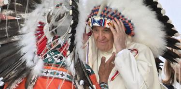 El papa Francisco recibe un sombrero de guerra durante su encuentro con un pueblo indígena para una plegaria silenciosa cerca de Edmonton, Canadá, este lunes 25 de julio de 2022.