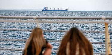 El barco ‘Razoni’ parte de Odesa, Ucrania, con 26 mil toneladas de grano para la exportación ante la mirada de dos chicas, este lunes 1 de agosto de 2022.