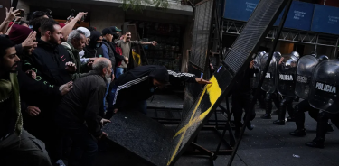 Militantes del movimiento kirchnerista radical La Cámpora derriba la barrera policial en torno a la vivienda de Cristina Fernández en Buenos Aires (Clarín)