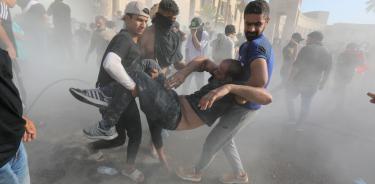 Seguidores del clérigo Mutqada al Sadr, sacan a un herido del Palacio Presidencial de Bagdad asaltado