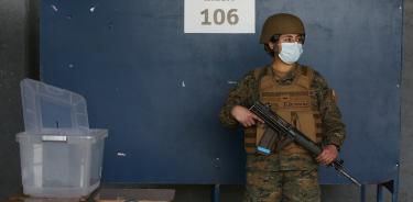 Una mujer del Ejército chileno custodia una de las casillas instaladas en el Estadio Nacional de Santiago para el plebiscito de este domingo