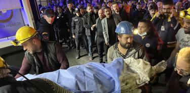 Trabajadores atienden mientras paramédicos sacan a un herido de la mina en Batin, Turquía, donde este viernes 14 de octubre murieron 41 personas por una explosión de grisú.