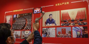 Un hombre captura la imagen de Xi jinping en una exhibición fotográfica en el Hotel Nikko, que alberga el vigésimo Congreso del PCCh, este sábado 15 de octubre de 2022 en Pekín.