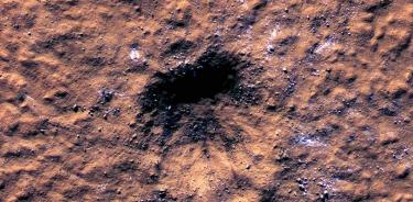 Se pueden ver bloques de hielo de agua del tamaño de una roca alrededor del borde de un cráter de impacto en Marte, vistos por el Mars Reconnaissance Orbiter de la NASA. El cráter se formó el 24 de diciembre de 2021 por el impacto de un meteorito en la región de Amazonis Planitia.