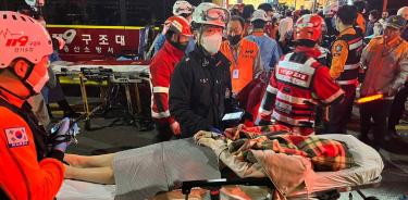 Paramédicos atienden a los heridos y levantan los cuerpos de personas fallecidas tras la estampida en Seúl