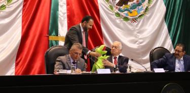 Manuel Bartlett Díaz, director general de la CFE, acepta el dinosaurio de regalo que le dio un diputado del PRD durante su comparecencia en San Lázaro.