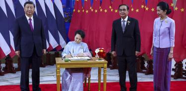 Xi Jinping posa junto a su esposa, Peng Liyuan, mientras esta escribe en el libro de visitas de la APEC, ayer en Bangkok.
