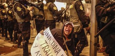 Una mujer grita tras una línea policial durante las protestas de este jueves 15 de diciembre de 2022 en Lima, Perú.
